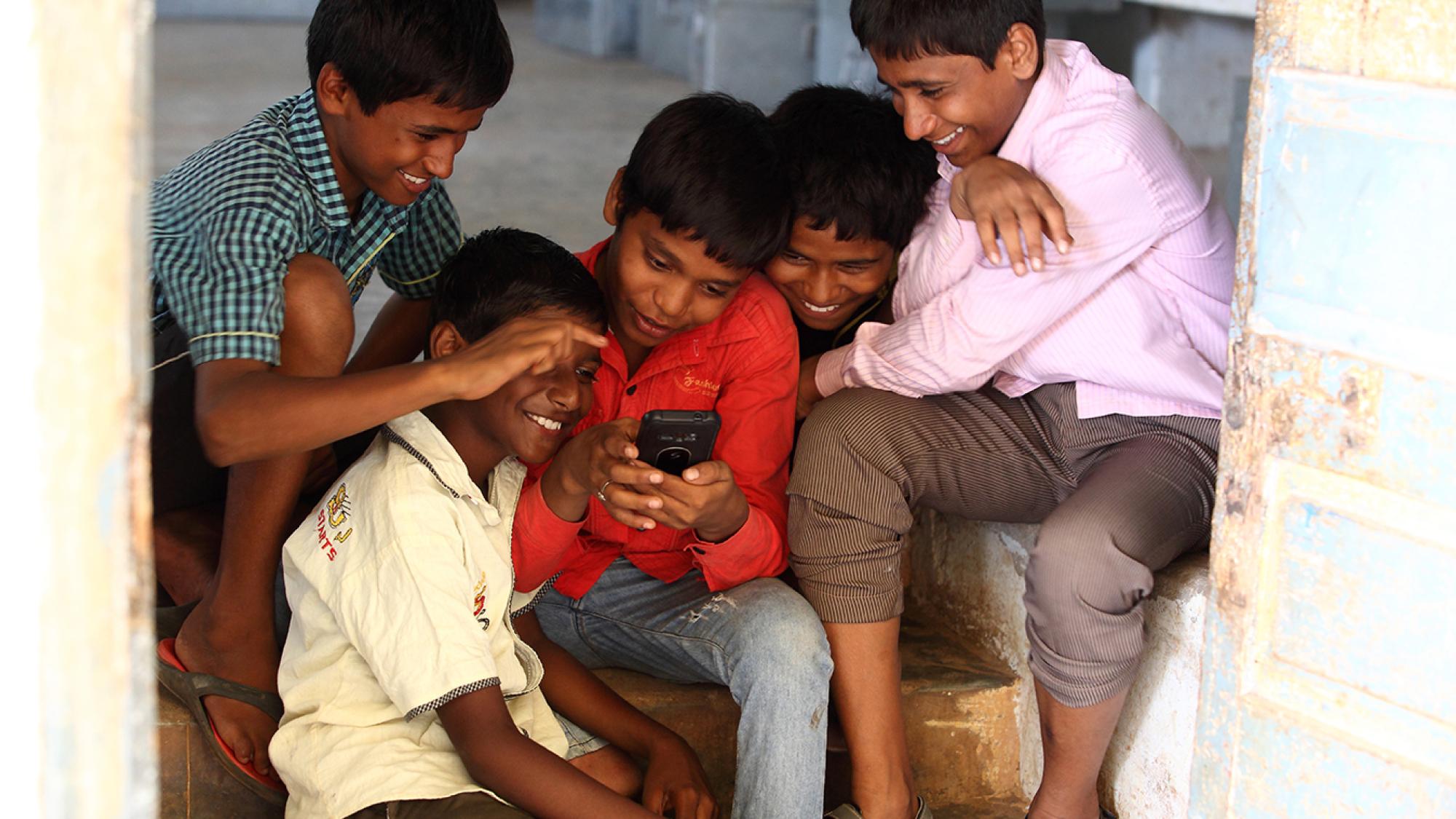 Boys watching a phone in India